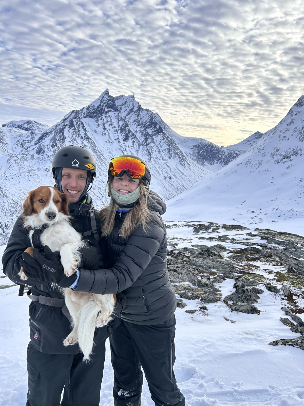 Olle Grönvall med partner och hund i famnen, iklädda skidkläder i ett snöigt alplandskap.