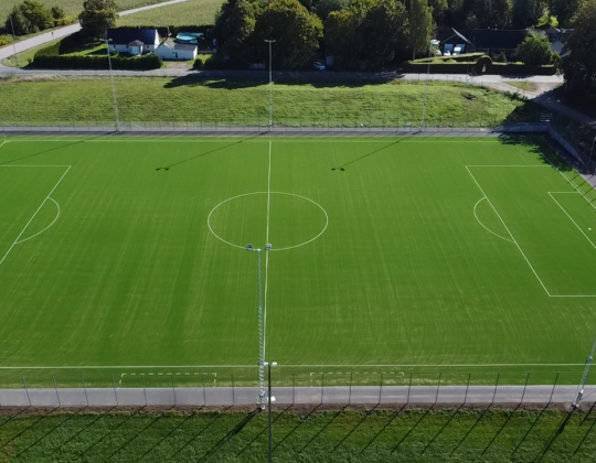 Drönarbild på konstgräsplan i Ljungbyhed. Runt planen gröna träd